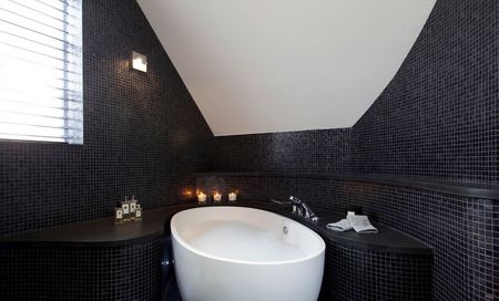 Белая ванна в сочетании с черной плиткой